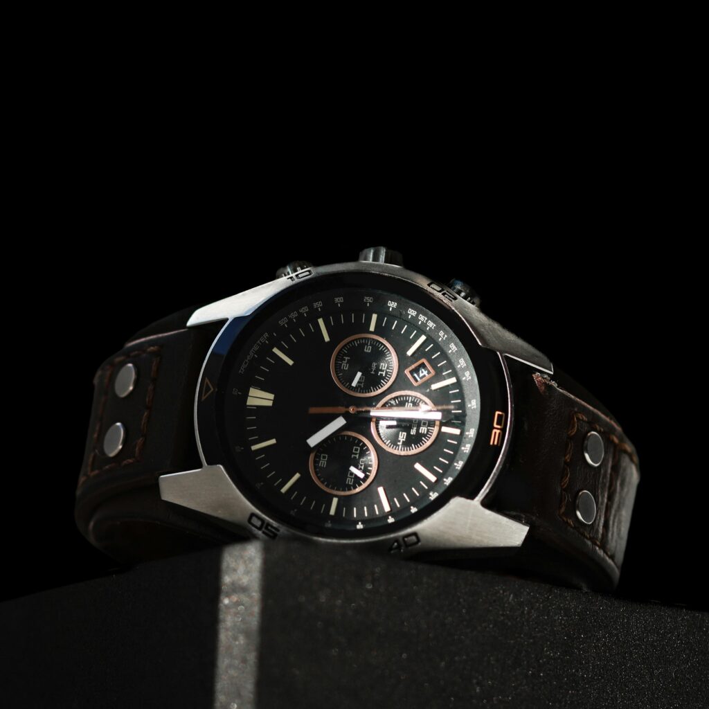 Close-up of a luxury chronograph wristwatch with a leather strap against a black background.
