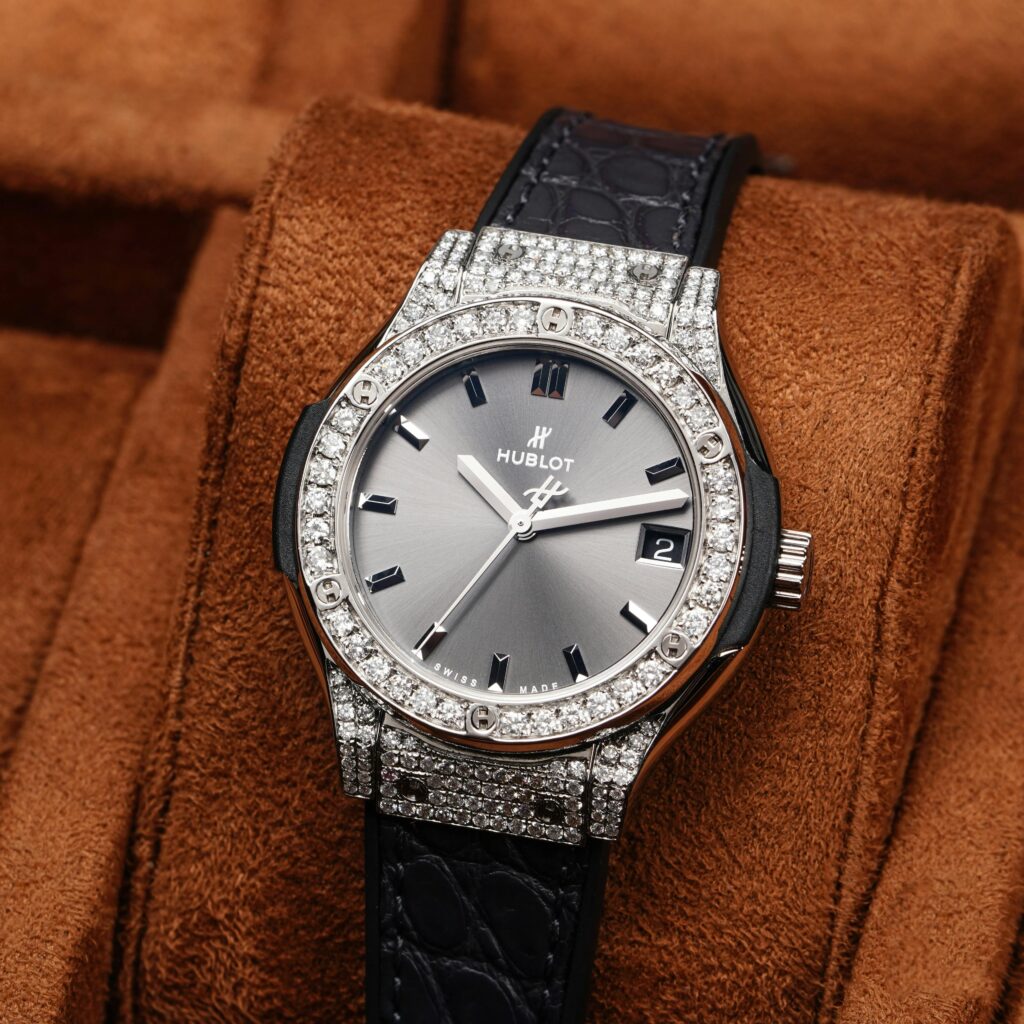 Elegant diamond-encrusted wristwatch with leather strap showcased on a brown velvet display.